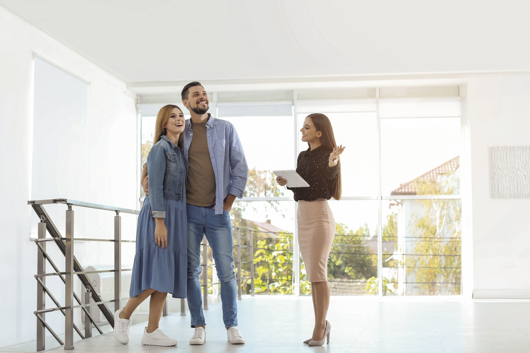 Female real estate agent showing new house to couple, indoors